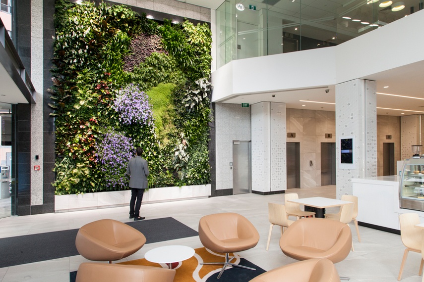 A large green wall in a large atrium.